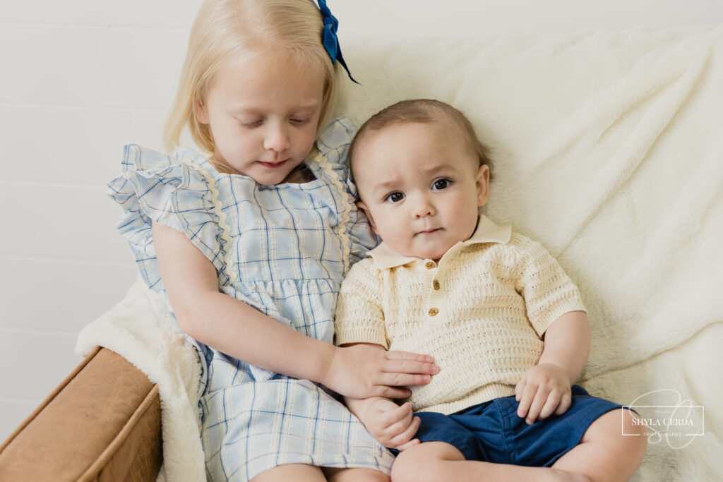 Baby boy and his three year old sister hugging during a sibling portrait session at The Loft on Lincoln in Troy Ohio